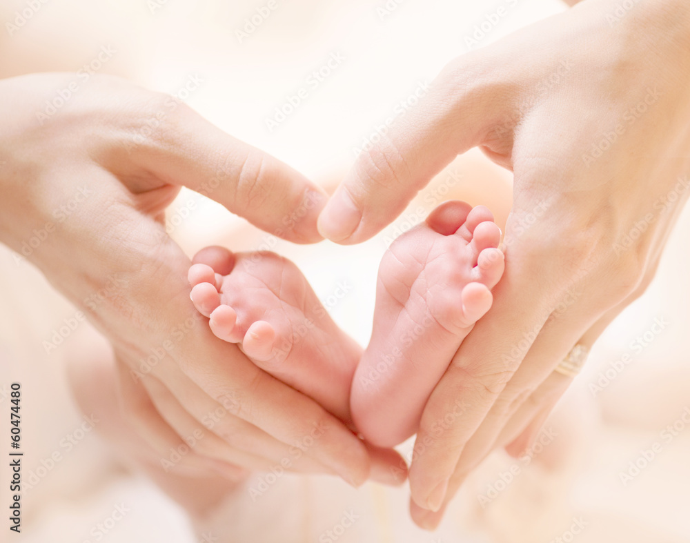 女性心形手上的微小新生儿脚特写