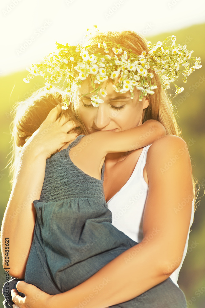 mother in a wreath in the embrace holding baby