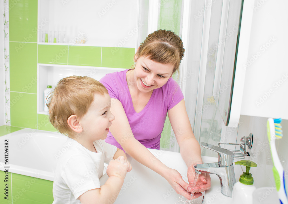 快乐的妈妈和孩子在浴室里一起用肥皂洗手