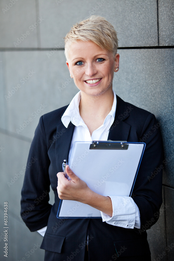 Attractive businesswoman holding clipboard