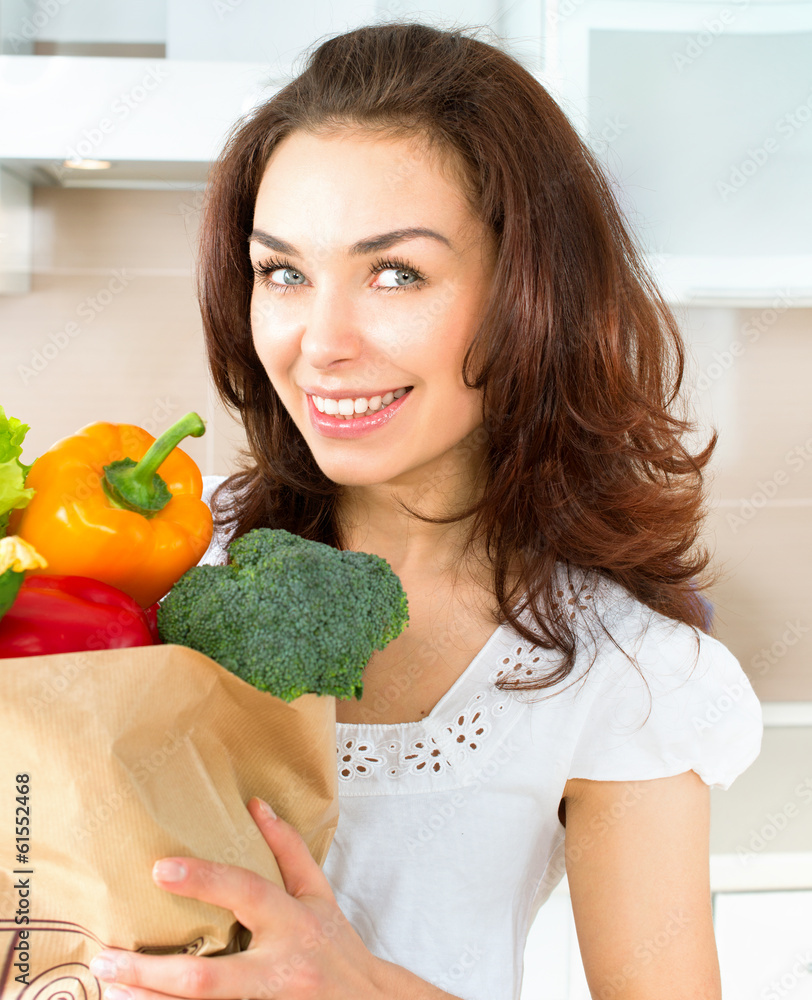 购物袋里有蔬菜的快乐年轻女人。饮食概念