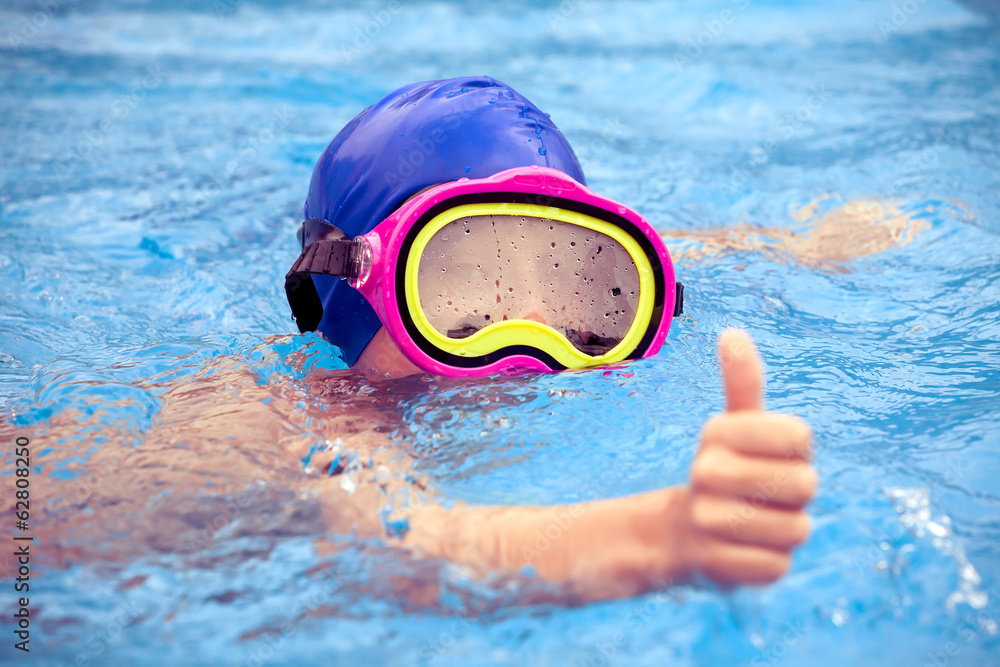 游泳池里戴着游泳面罩的孩子竖起大拇指