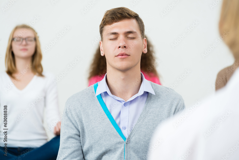 young man, meditating with closed eyes