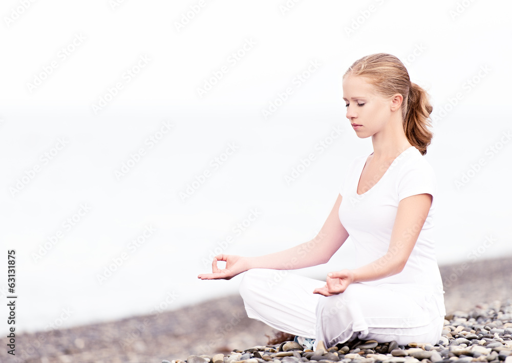 女人在海滩上做莲花瑜伽冥想