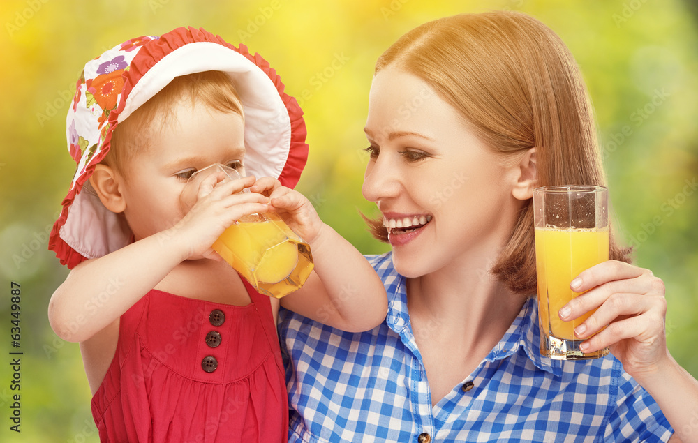 家庭母亲和婴儿女儿一起喝橙汁