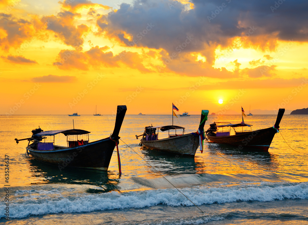日落海滩上的传统泰国船
