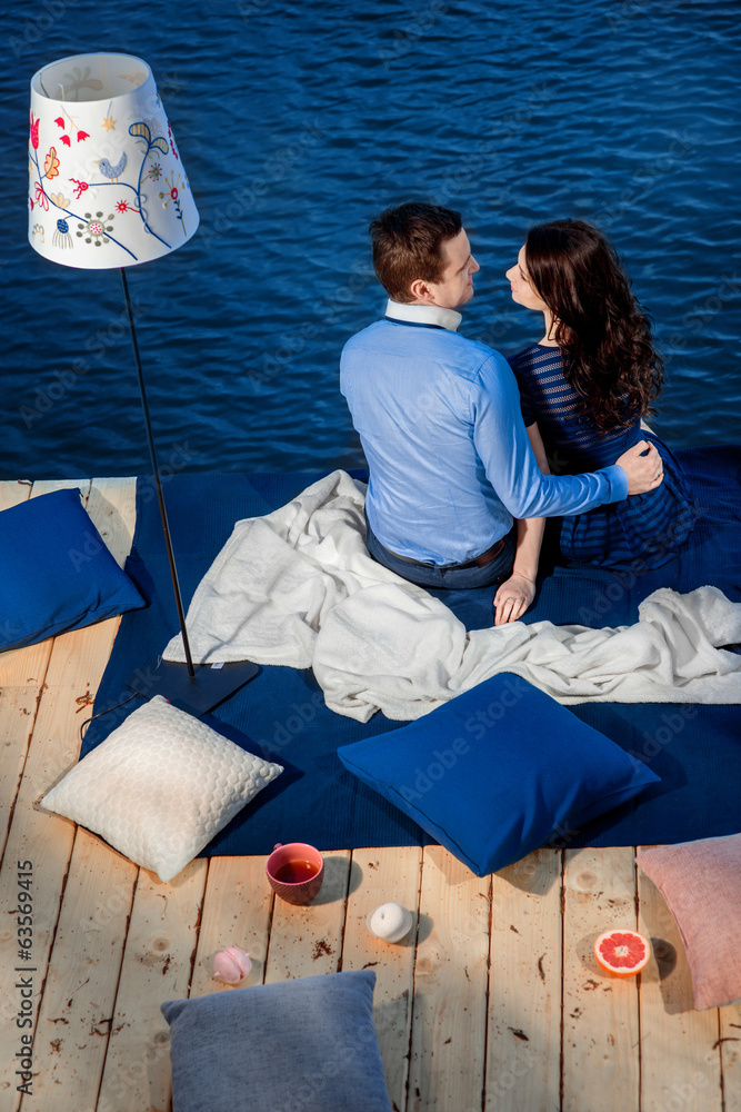 恋爱中的年轻情侣在水边的露台上放松