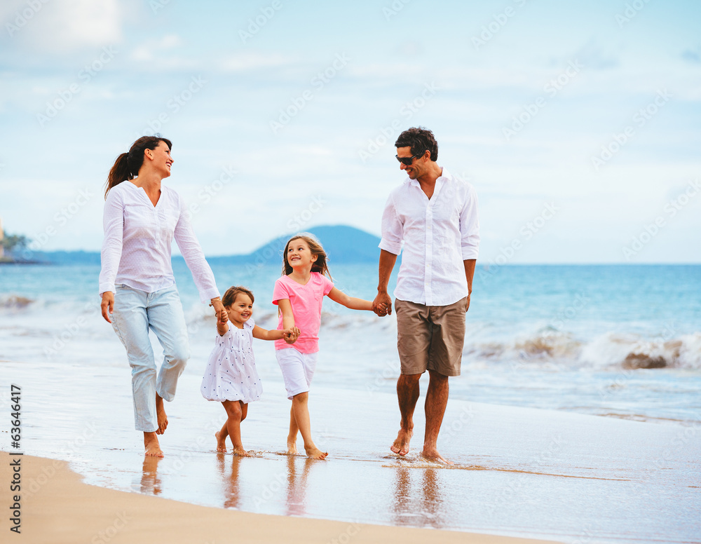 快乐的年轻家庭在海滩上漫步