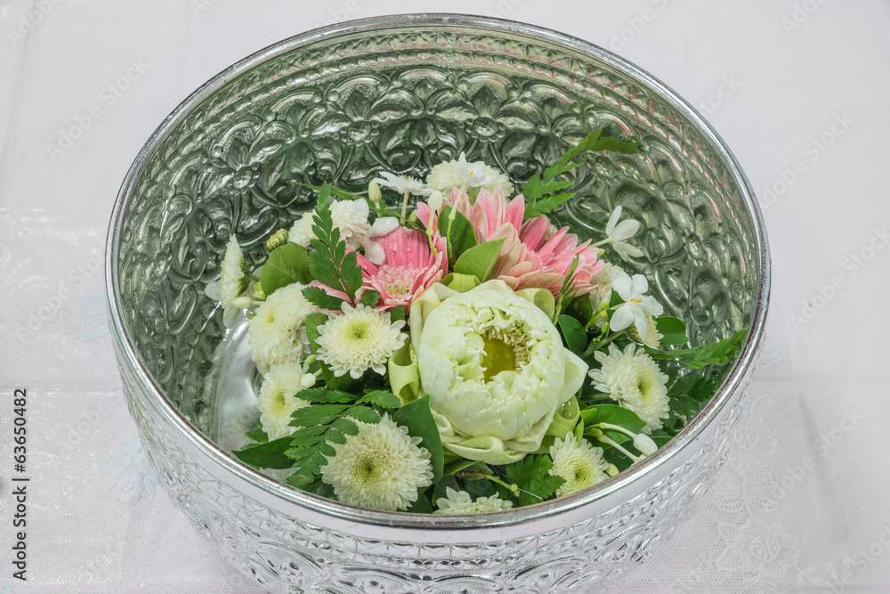 银质碗中带有泰式装饰的莲花和非洲菊