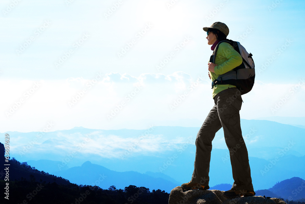 蓝色山脉背景下的女性徒步旅行者。