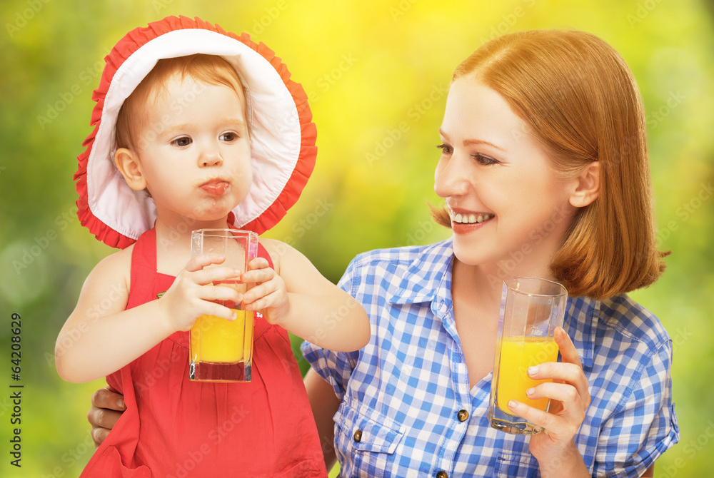 家庭母亲和婴儿女儿一起喝橙汁