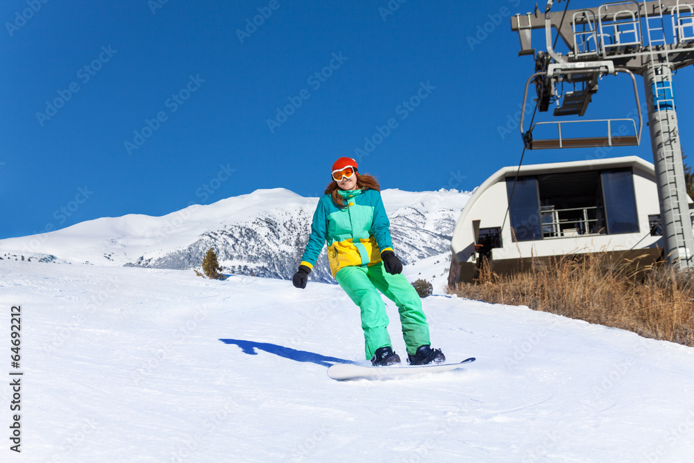 戴着滑雪面罩的女孩在滑雪板上滑行