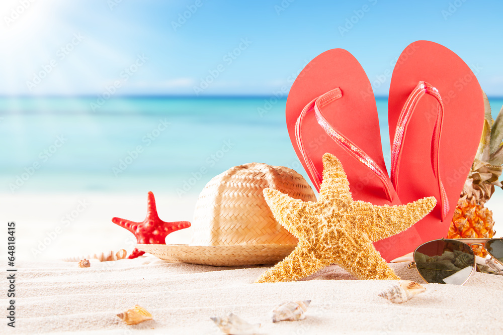 Summer beach with straw hat, seashells and sandals