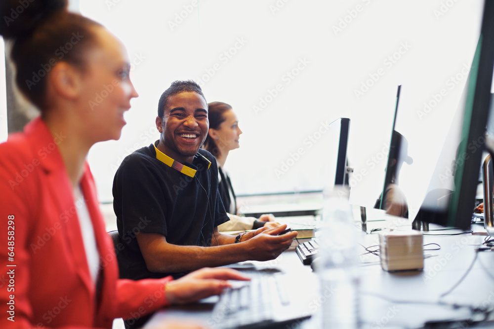 班上的年轻学生和其他学生一起使用电脑