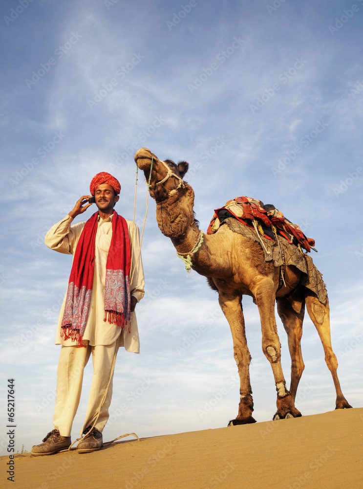 沙漠中的亚洲人和骆驼与通讯