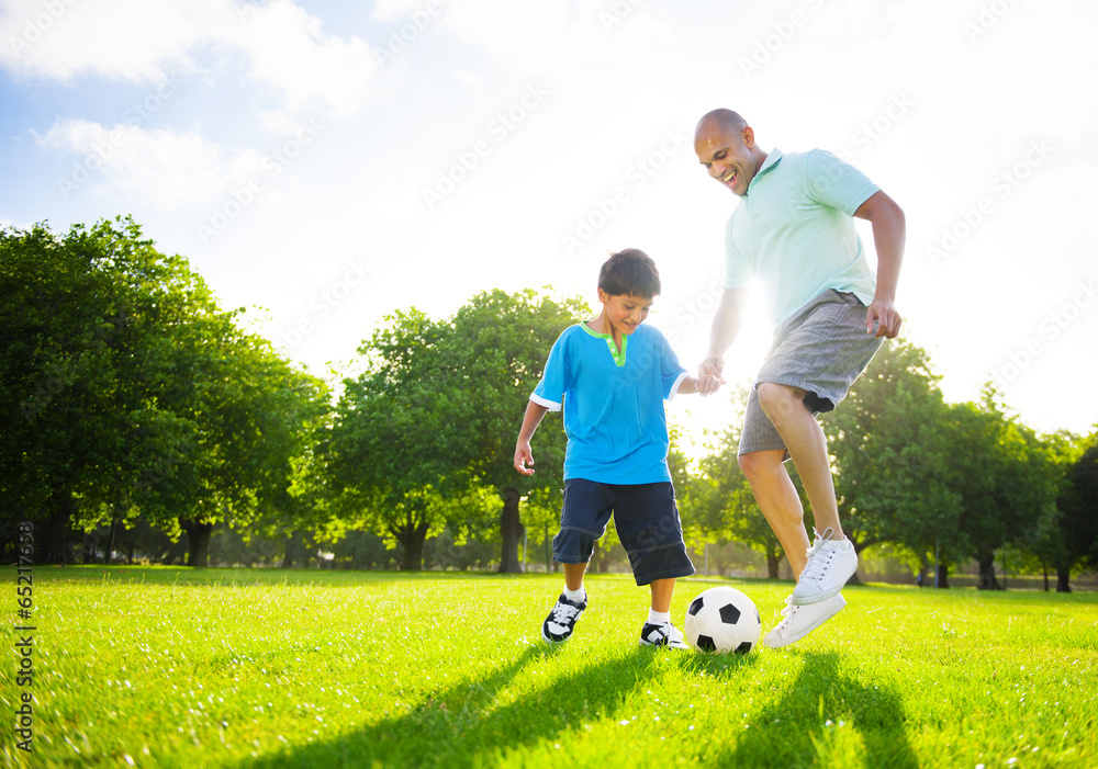 小男孩和父亲一起踢足球