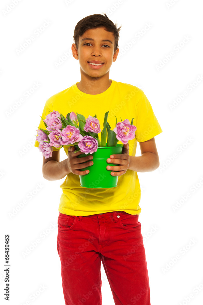 Happy boy holding pail with pink tulips