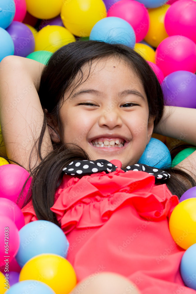 快乐的亚洲孩子在幼儿园玩五颜六色的球