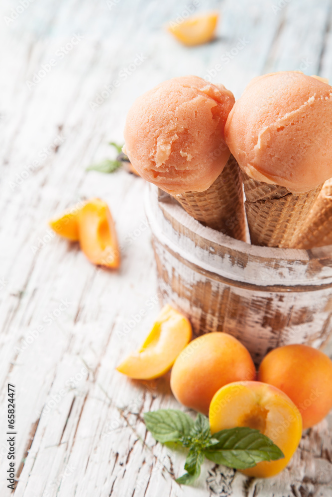 杏子新鲜冰淇淋勺装在木头上的甜筒里