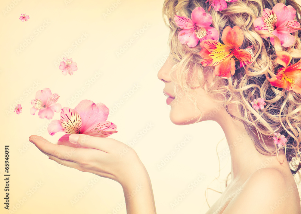 女孩手里拿着漂亮的花。吹着花