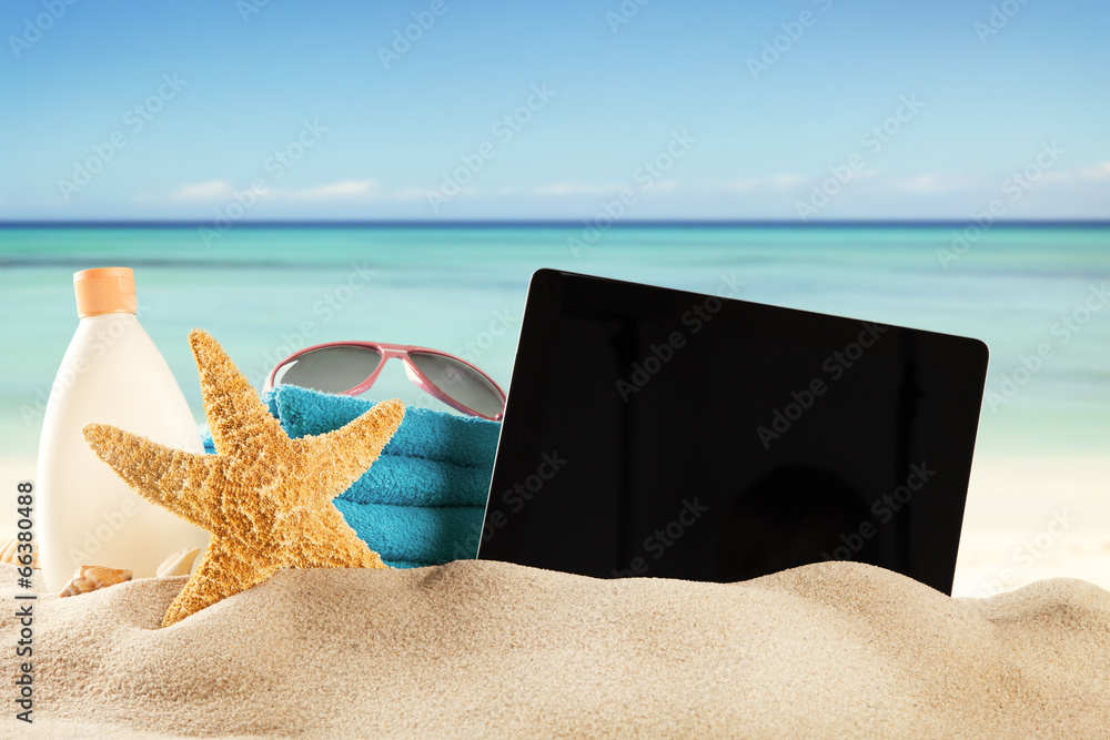Summer beach with tablet in sand