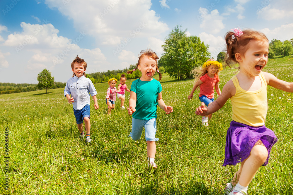 兴奋奔跑的孩子们在绿地上一起玩耍