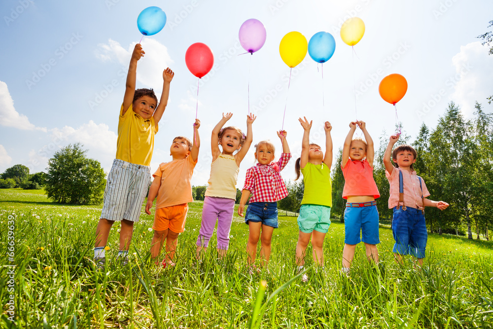 快乐的孩子们，高举气球，高举双臂