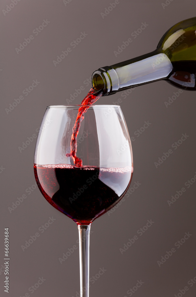 葡萄酒倒在灰色背景的玻璃杯中