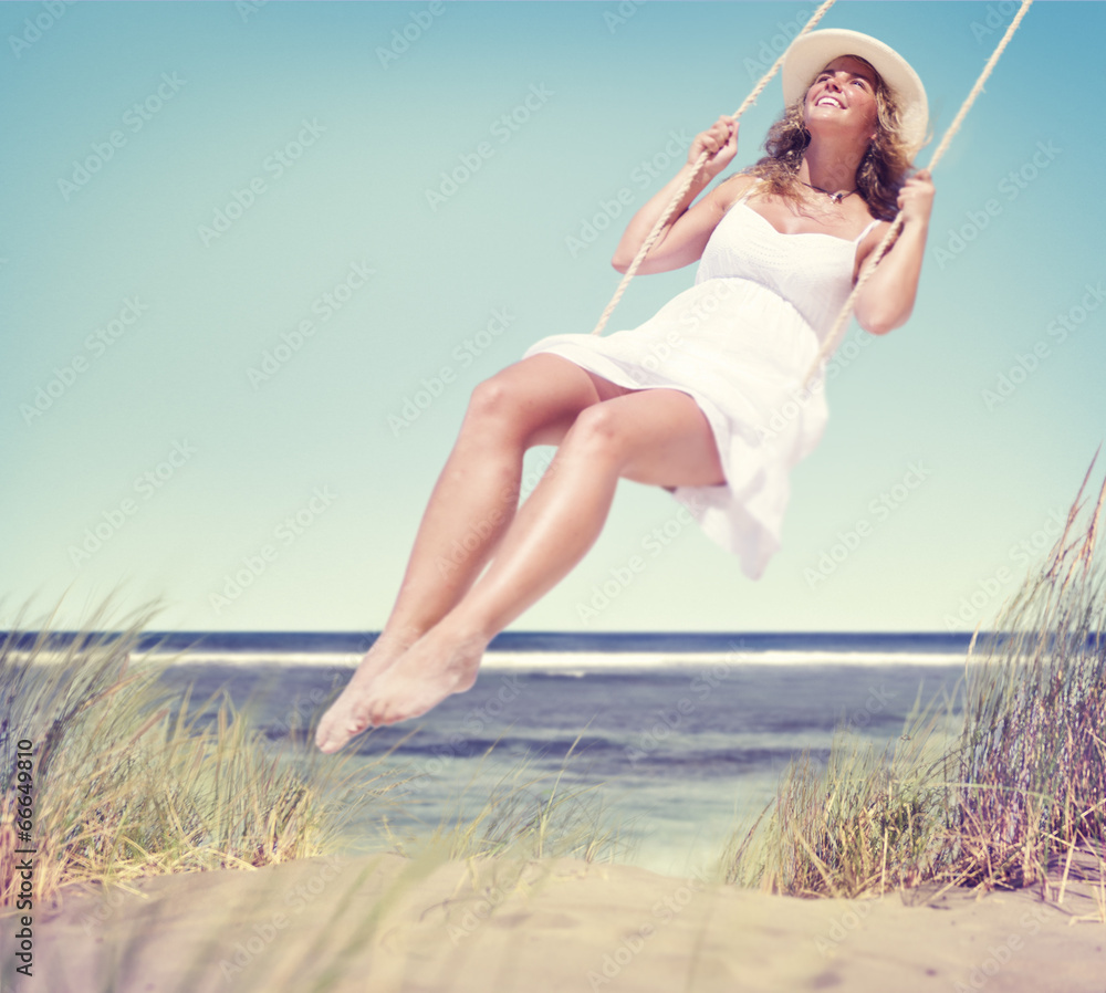 Beautiful Cheerful Woman Swinging by the Beach