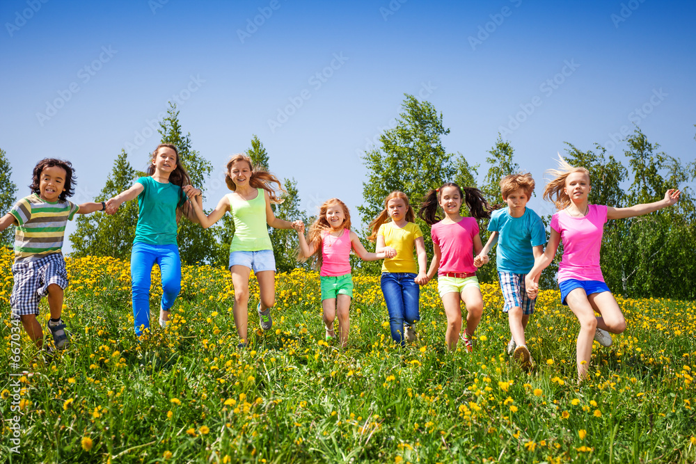 嬉戏的孩子们奔跑，在绿色的田野里牵着手