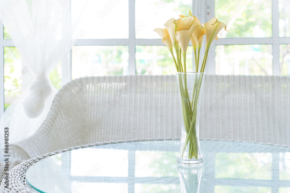 桌子和窗台背景上花瓶里的黄色花朵。复古