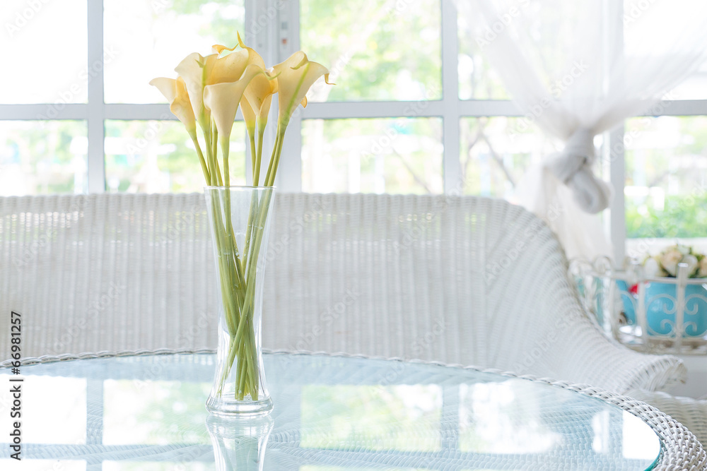 Yellow flower in vase on table and window sill background. Vinta