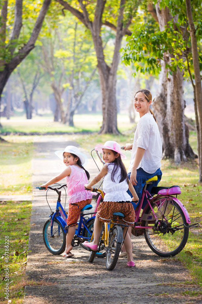 亚洲儿童与母亲一起骑自行车，积极的家庭观念