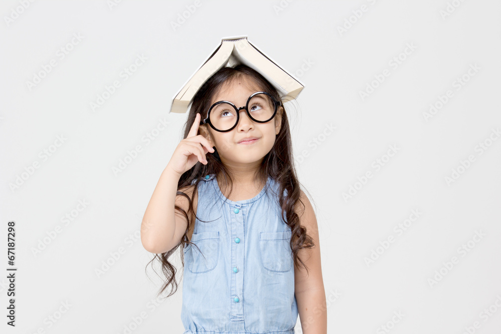 头顶一本书思考的亚洲小孩画像