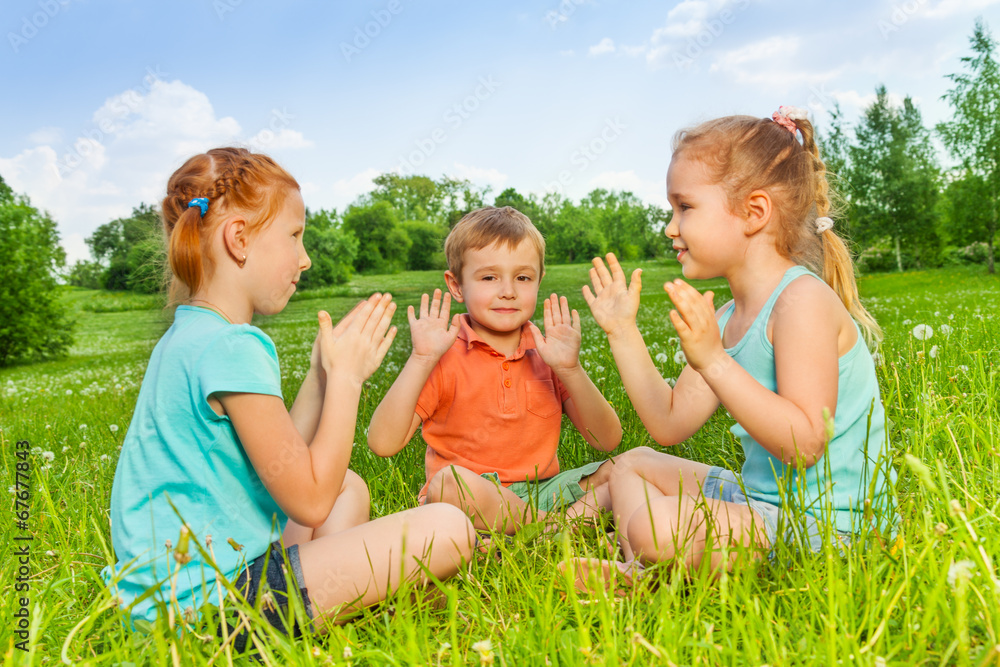 Three kids playing on a grass