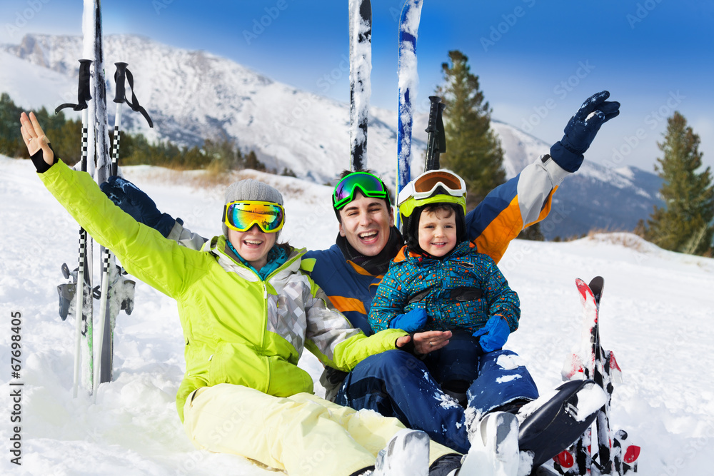 滑雪后在雪地上举起双手的幸福家庭