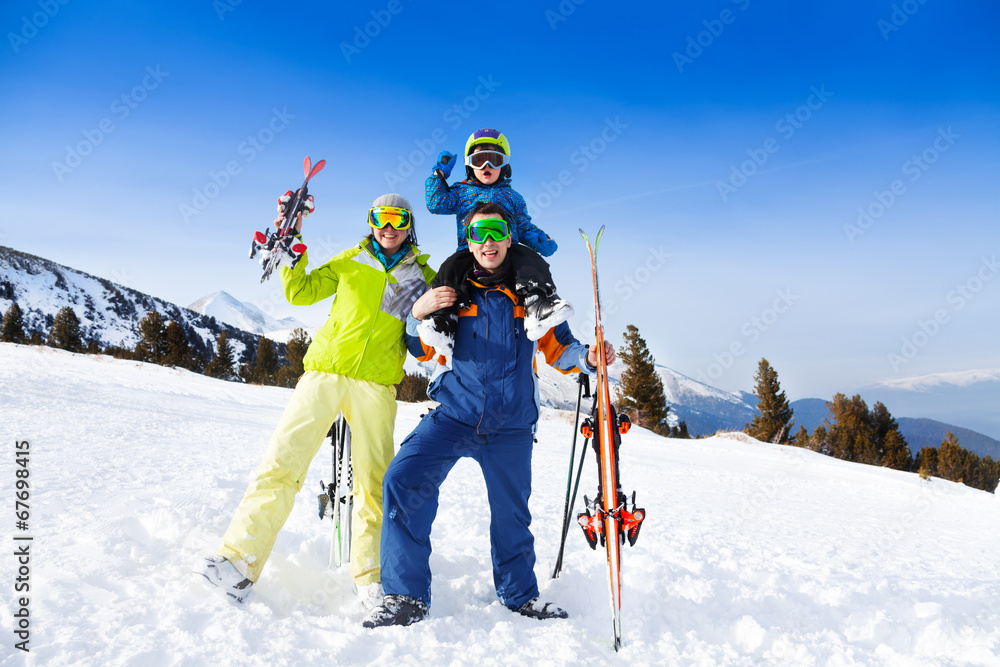 妈妈，爸爸肩上扛着孩子，戴着滑雪面罩