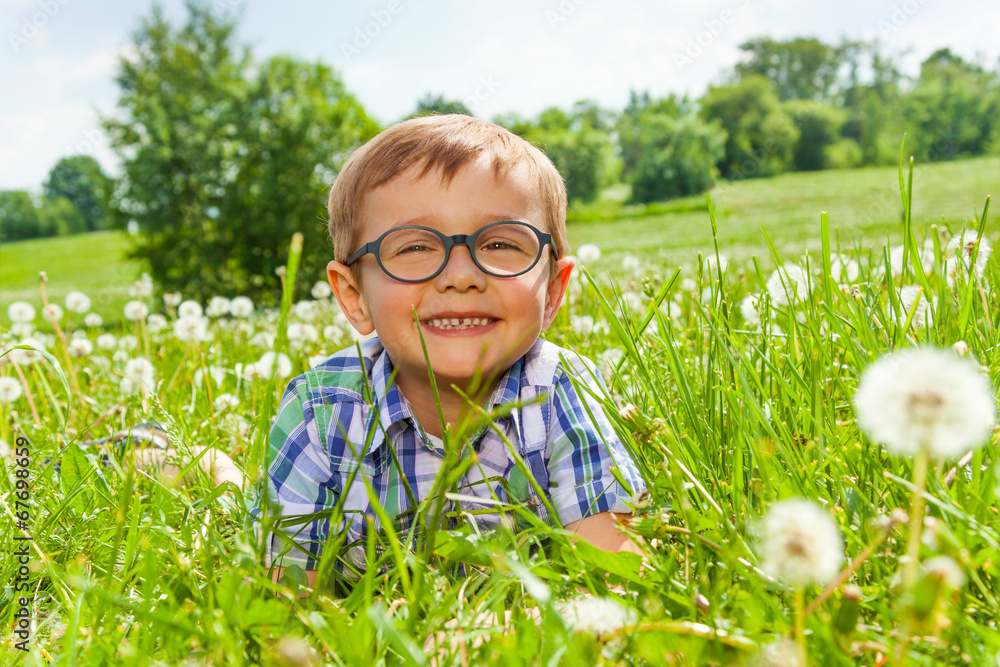 微笑的小男孩躺在草地上