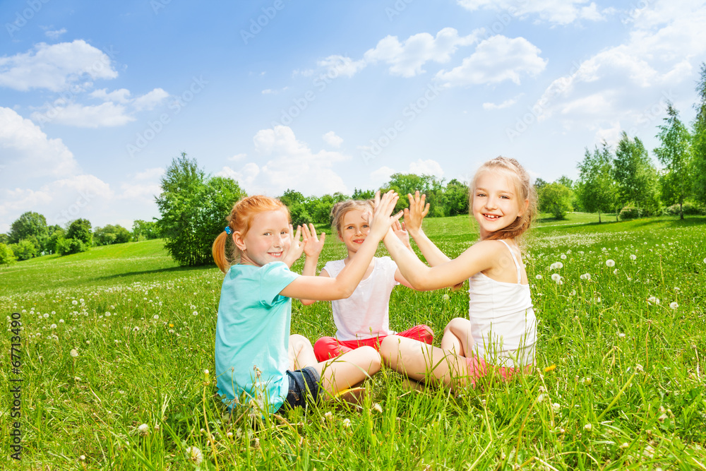 三个孩子在草地上玩耍