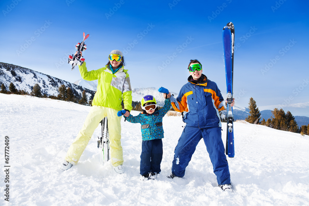 戴着滑雪面罩的积极父母牵着儿子的手