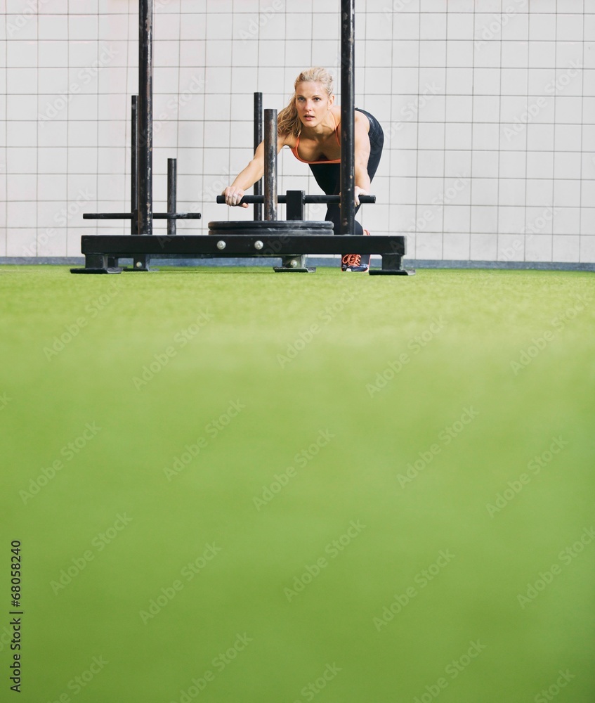 在健身房使用潜行运动器材为年轻女性健身