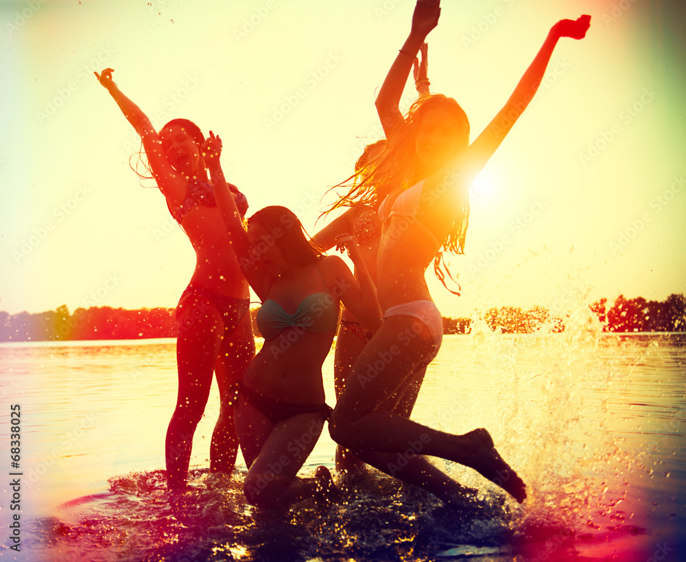 海滩派对。青少年女孩在水中玩得很开心