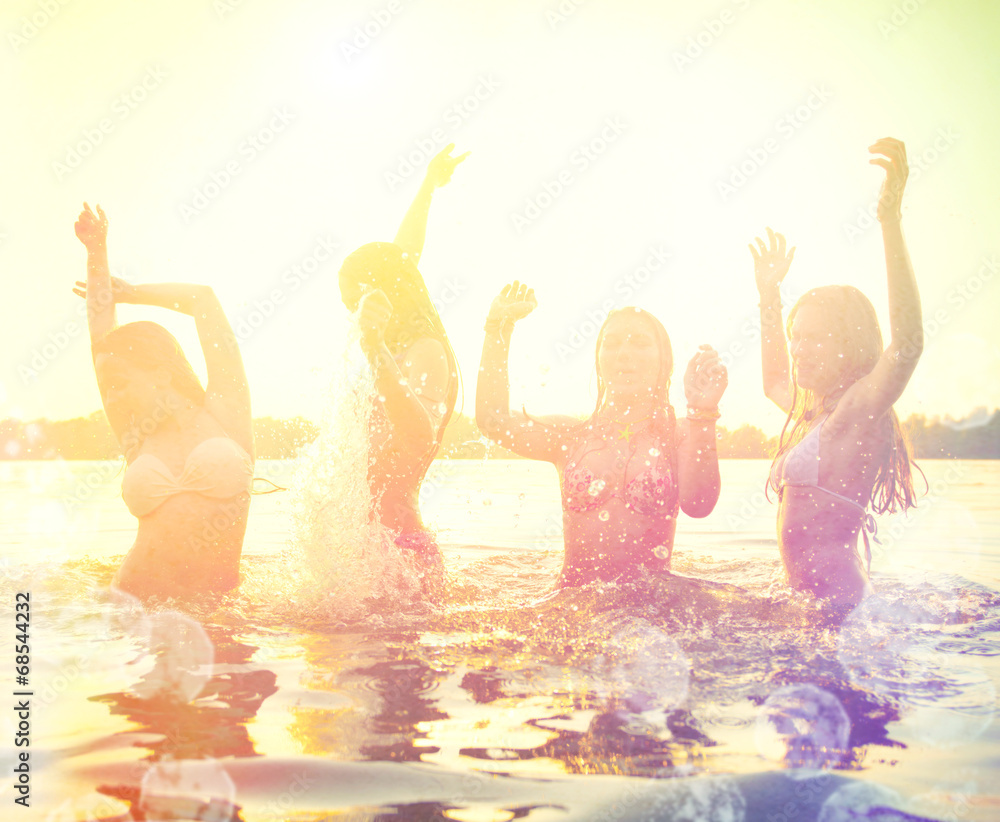 一群快乐的少女在日落的海滩上玩耍
