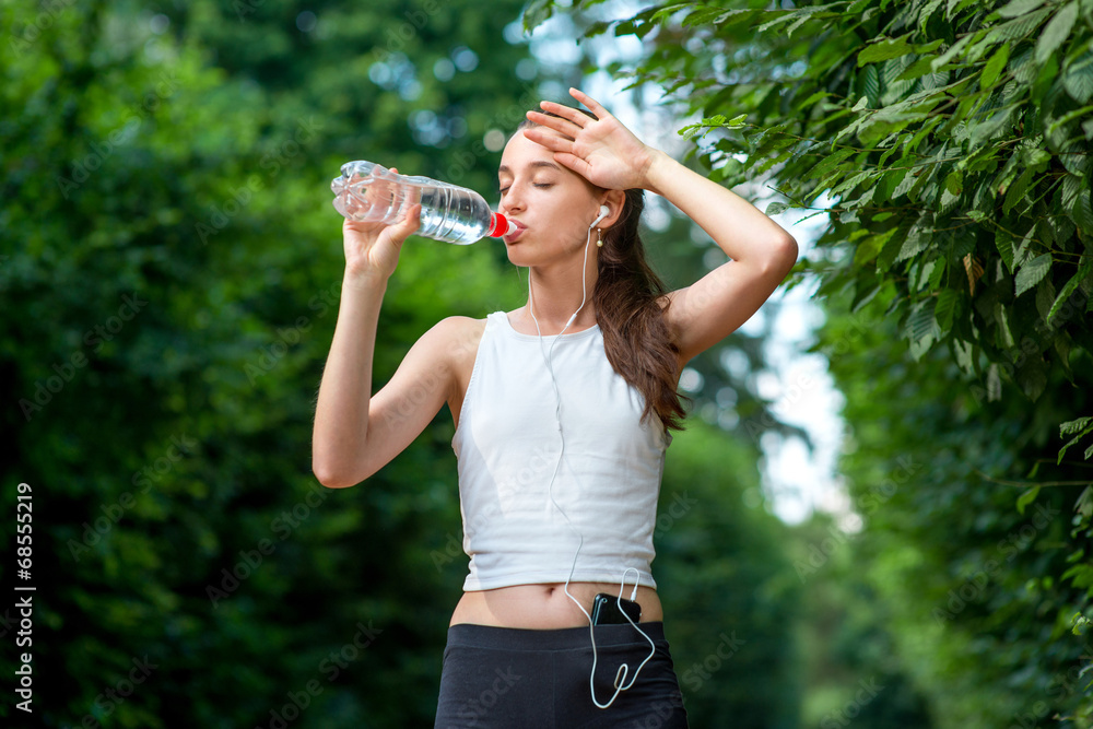 女运动员休息。喝水，在外面跑步