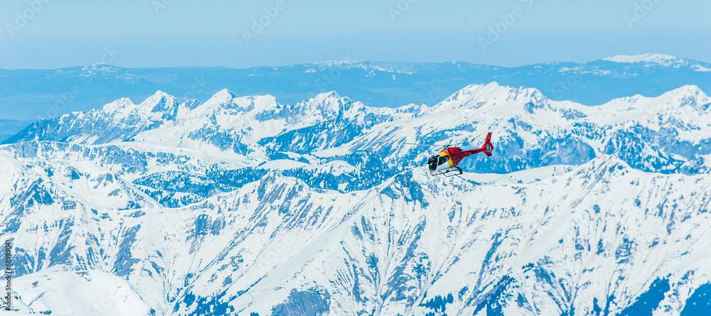 红色直升机飞越少女峰地区的雪山