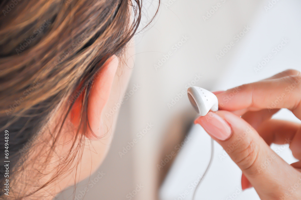 女人把耳机戴在耳朵里