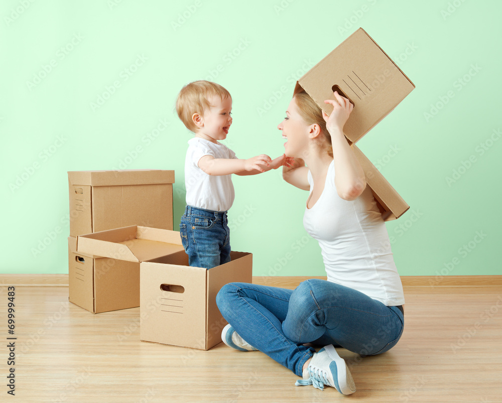 幸福的家庭母亲和婴儿女儿在公寓里有盒子
