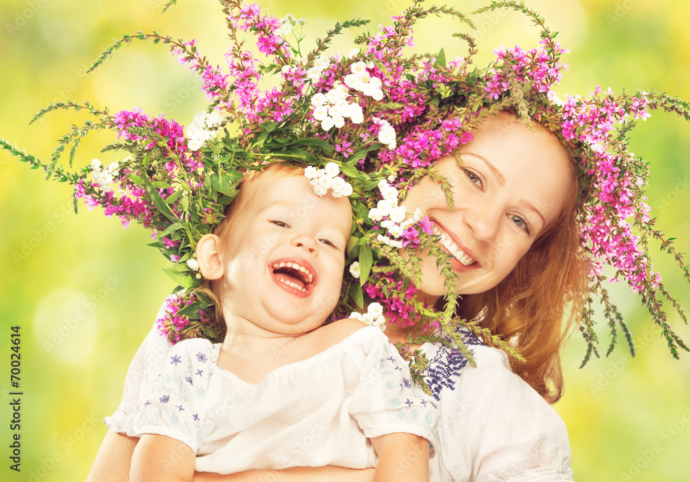 幸福的女儿在夏天的花圈里拥抱母亲
