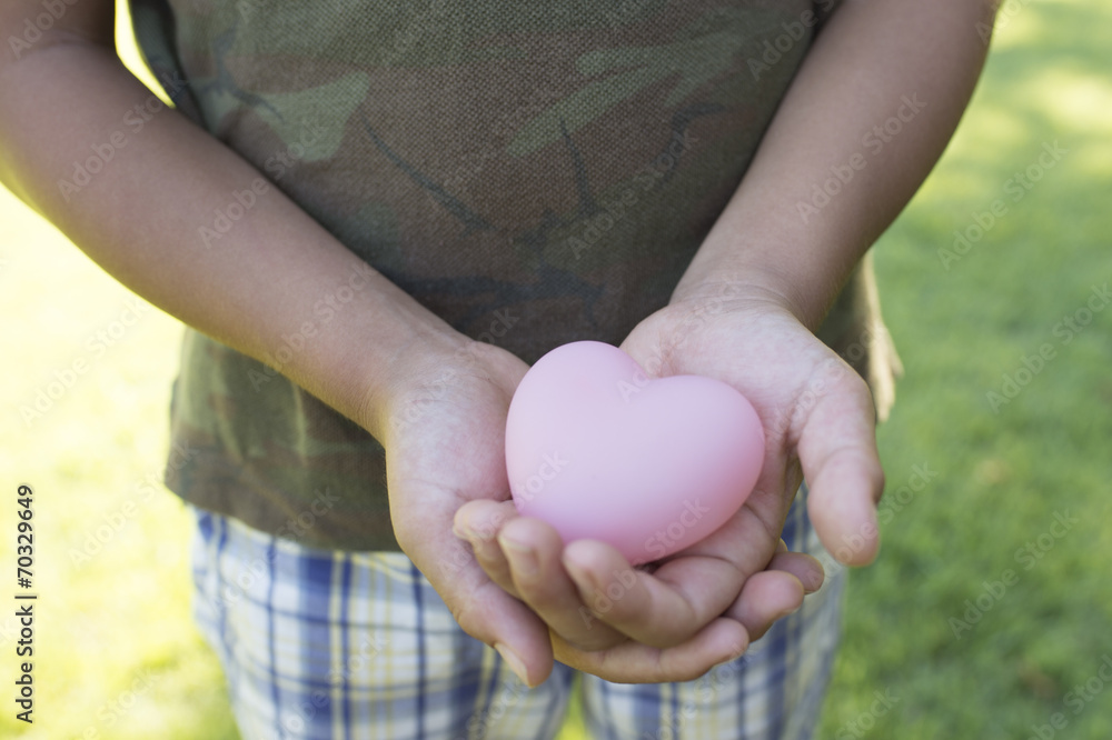 男孩抱着一颗粉红色的心