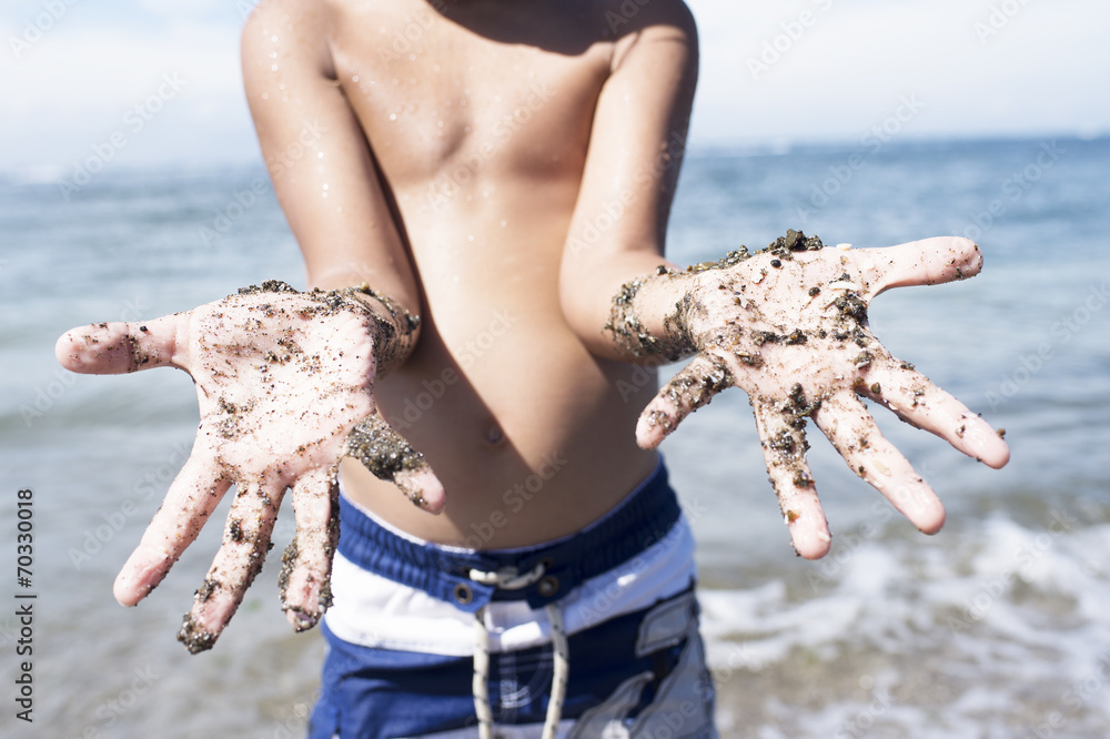 男孩展示被沙子弄脏的手掌